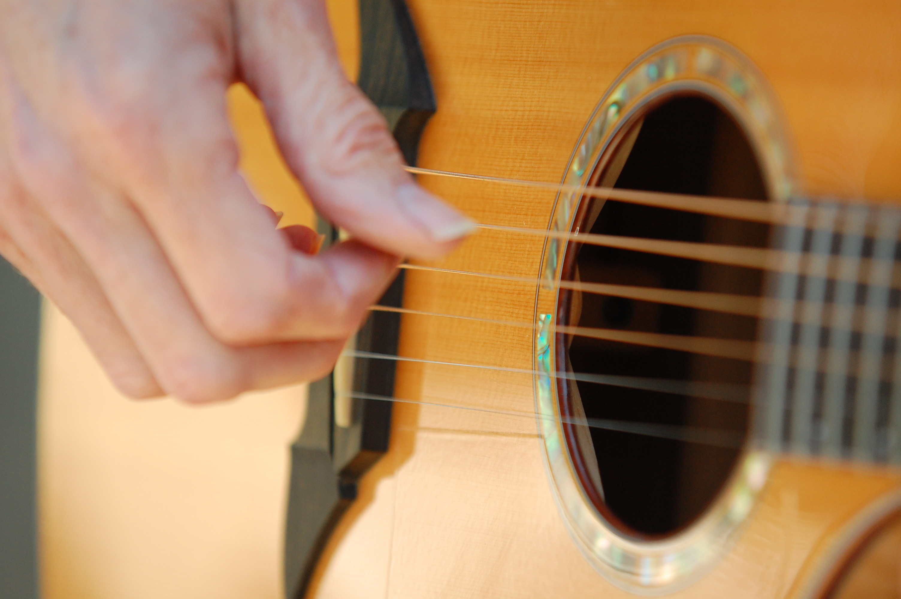 Kyle plucking the strings beside the soundhole of his Breedlove C12/MP guitar
