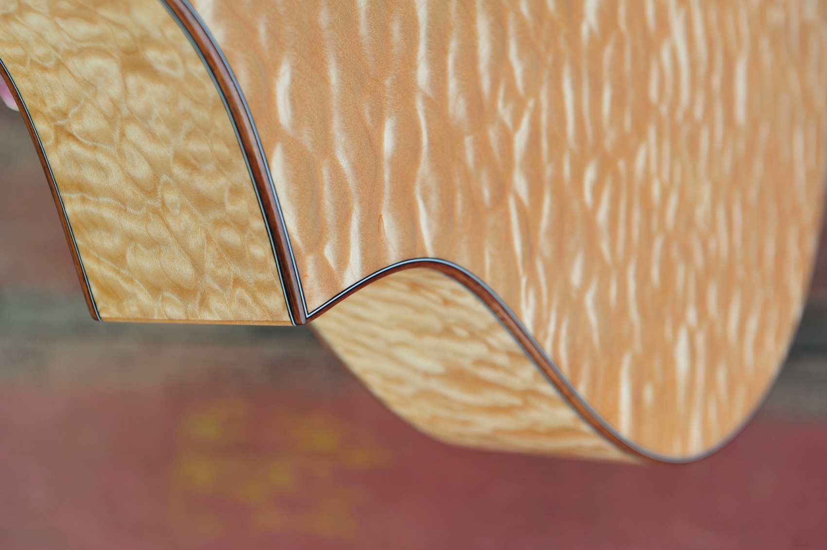 Close-up of the figured quilted-maple back of Kyle's Breedlove C12/MP guitar