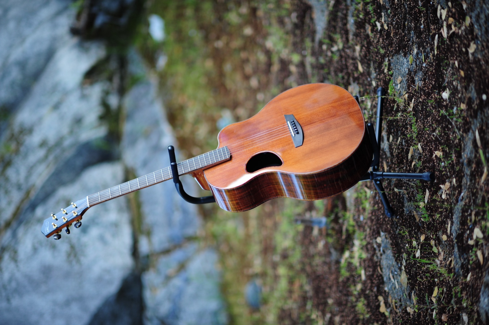 Kyle's McPherson MG 4.5 XP acoustic guitar standing on a stand outdoors against granite rocks