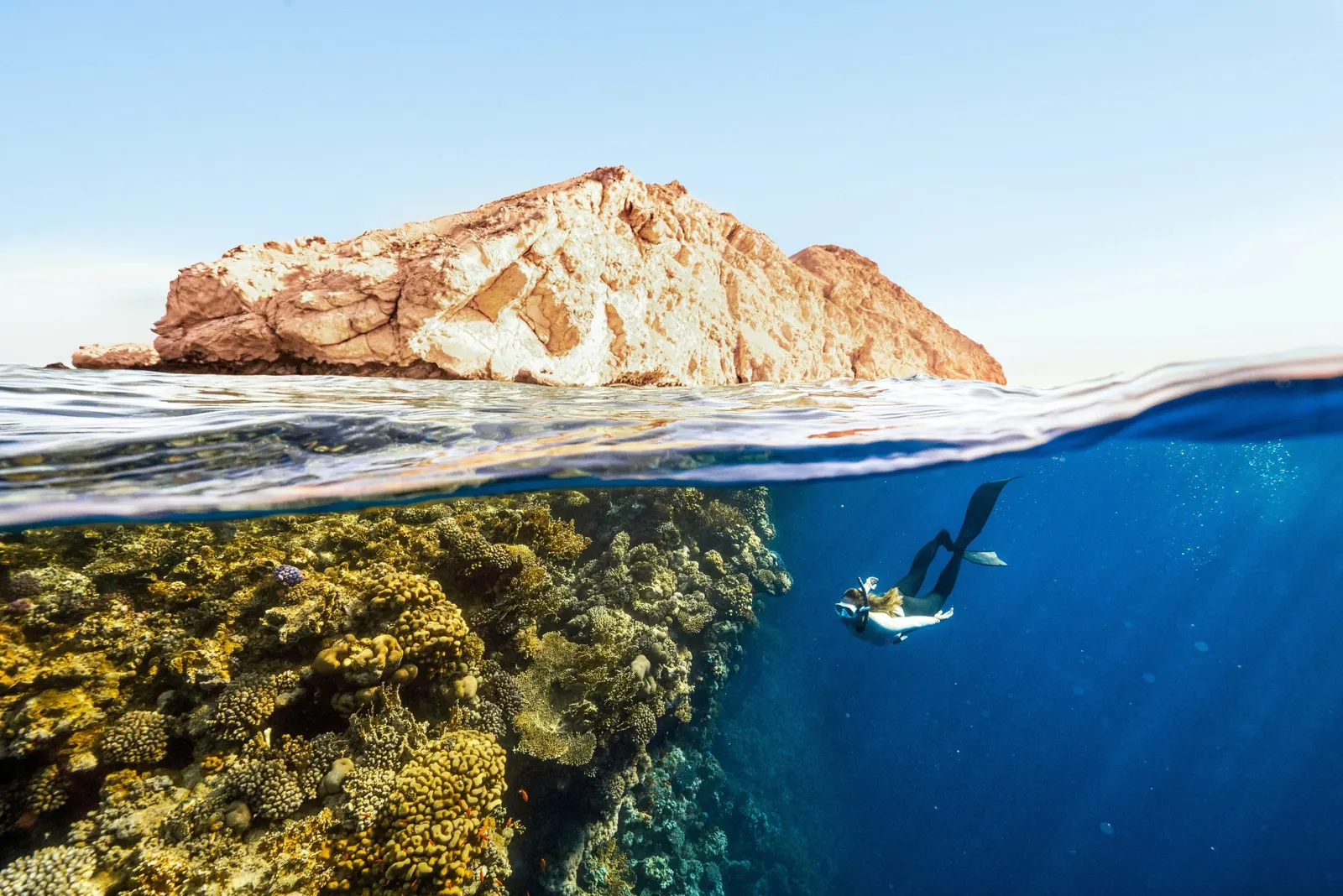 Apnéiste près d’un îlot rocheux et d’un récif, mer Rouge