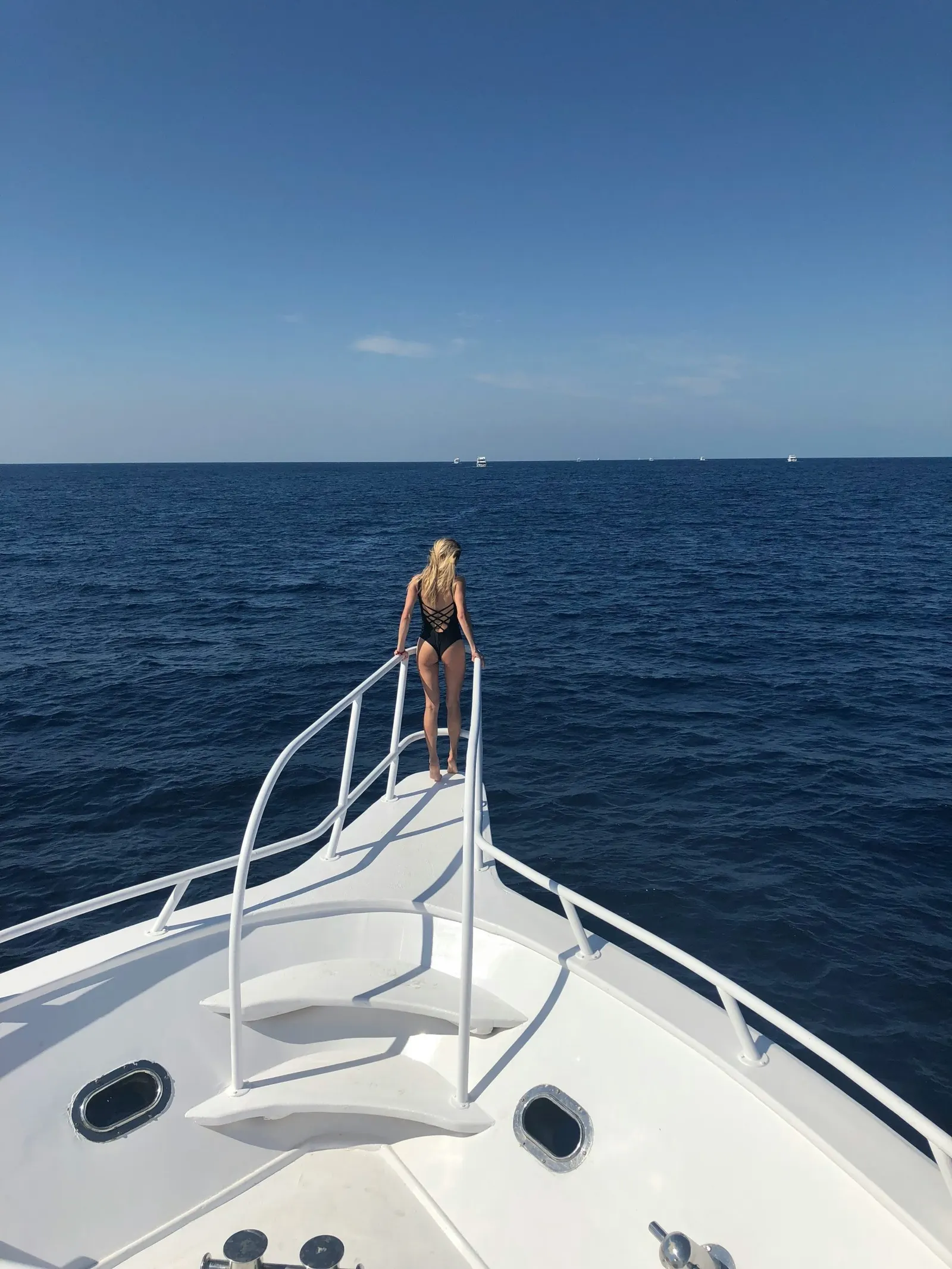Voyageuse seule à la proue d'un bateau en pleine mer