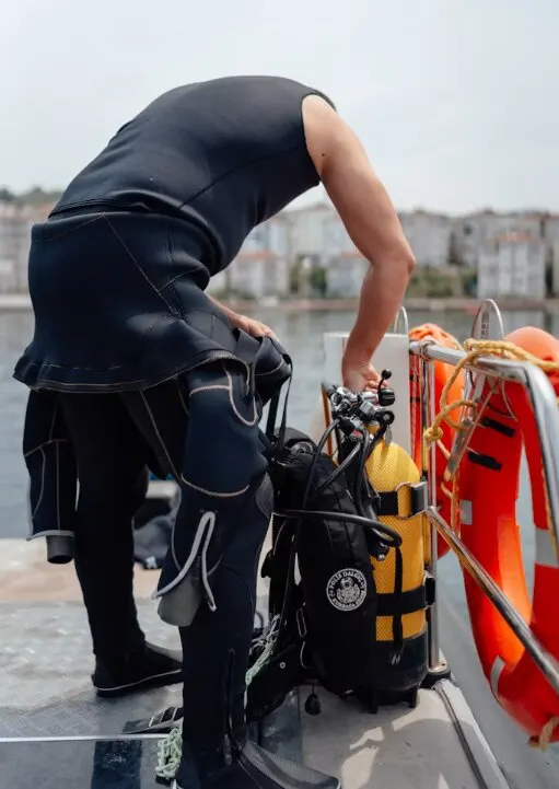 Plongeur en combinaison qui s'équipe sur le pont d'un bateau