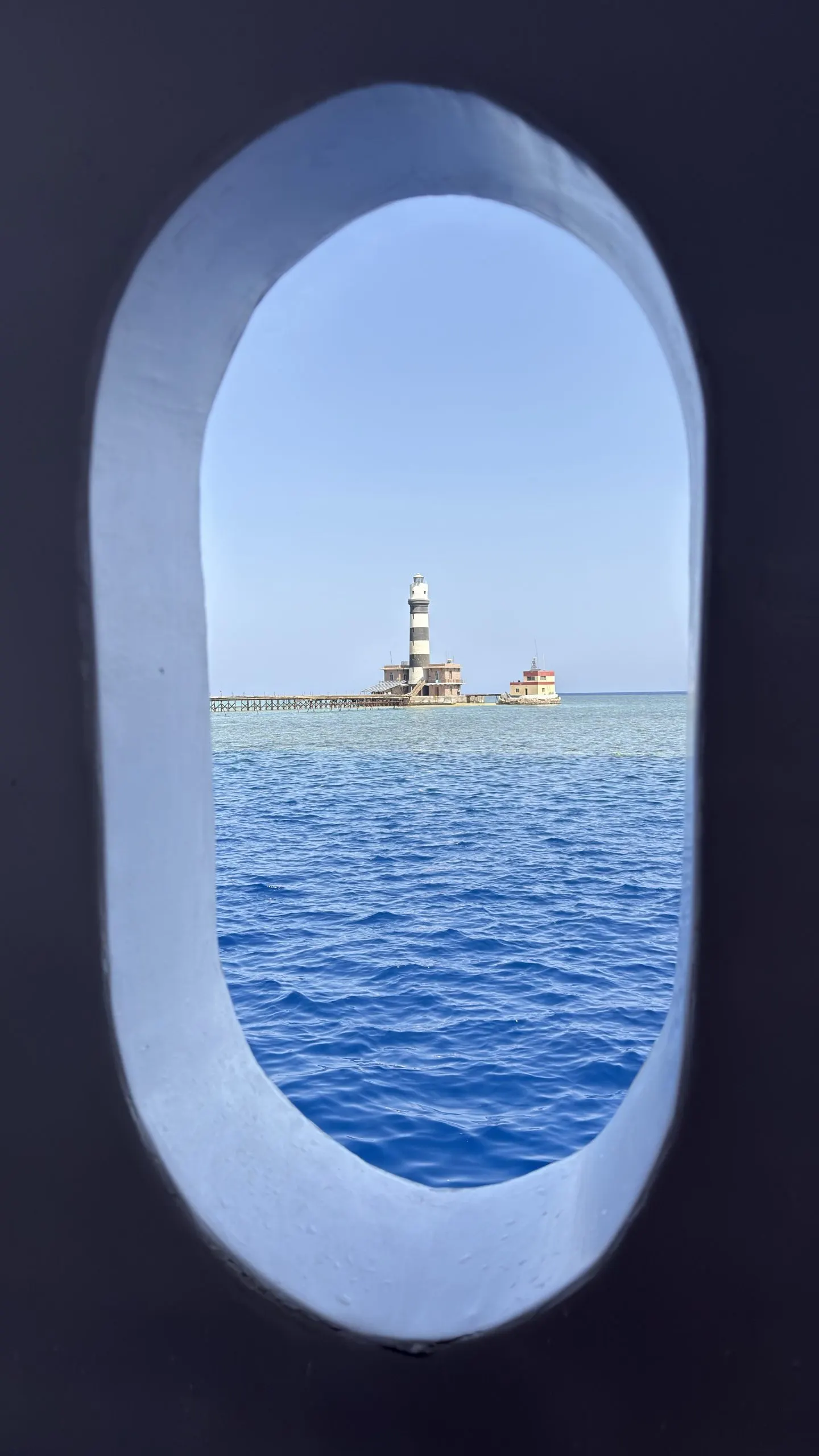 Le phare de Daedalus vu par un hublot de bateau