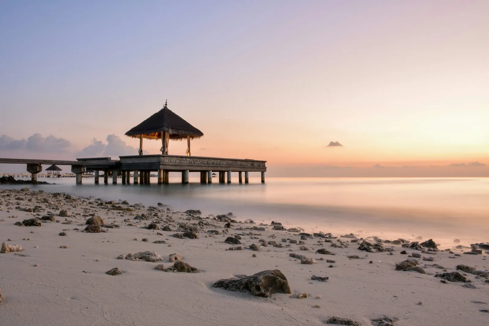 Plage et kiosque sur pilotis au coucher du soleil, Maldives