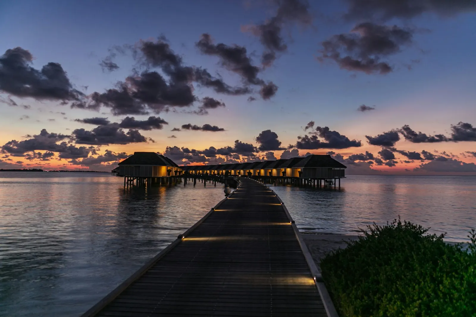 Ponton et bungalows sur pilotis au coucher du soleil, Maldives