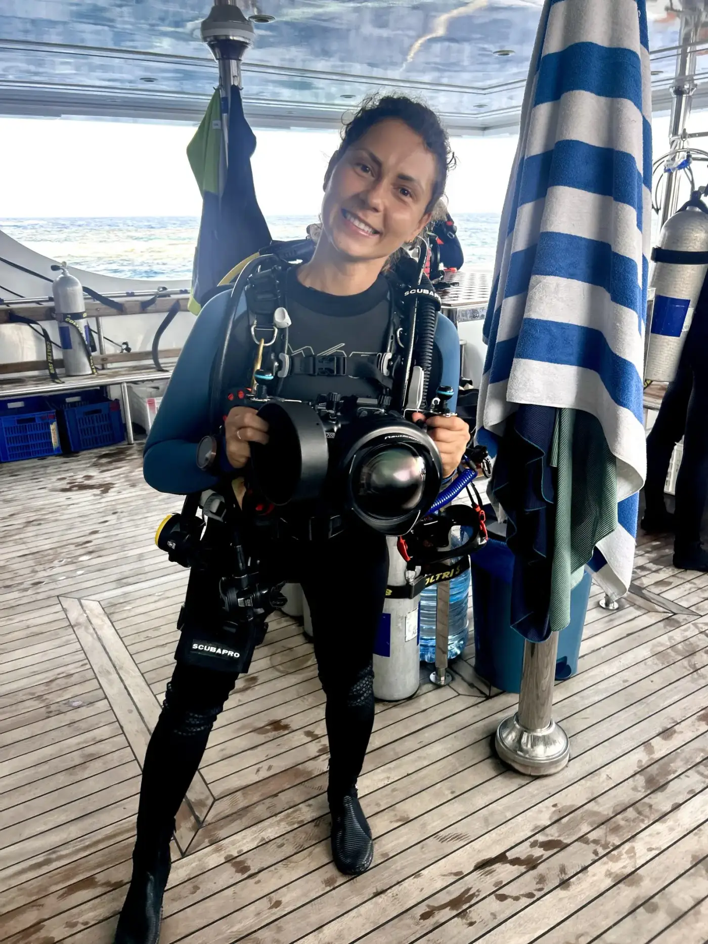 Photographe sous-marine avec son caisson sur le pont du bateau