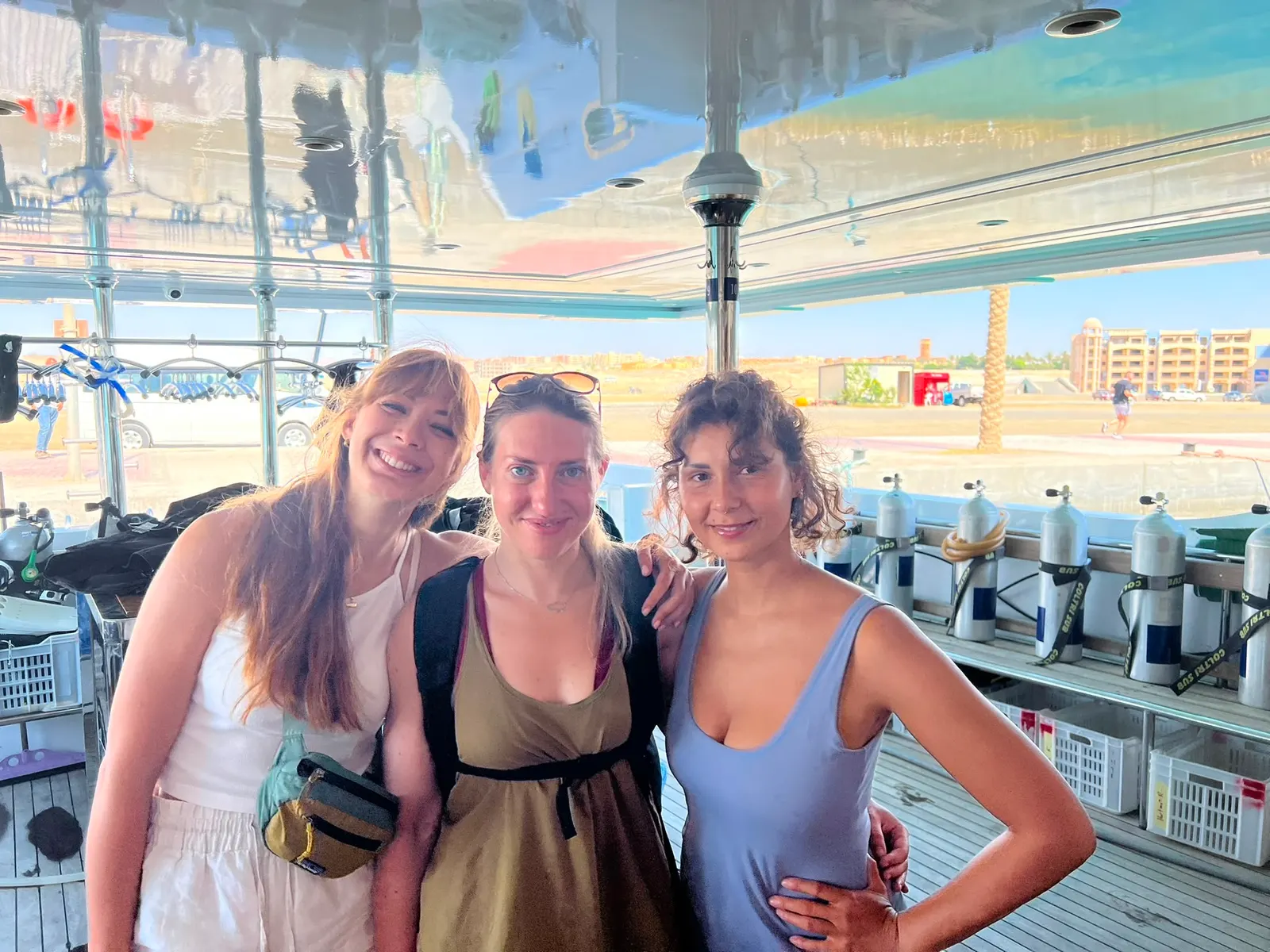 Trois amis souriants sur le pont de plongée d’un bateau en Égypte