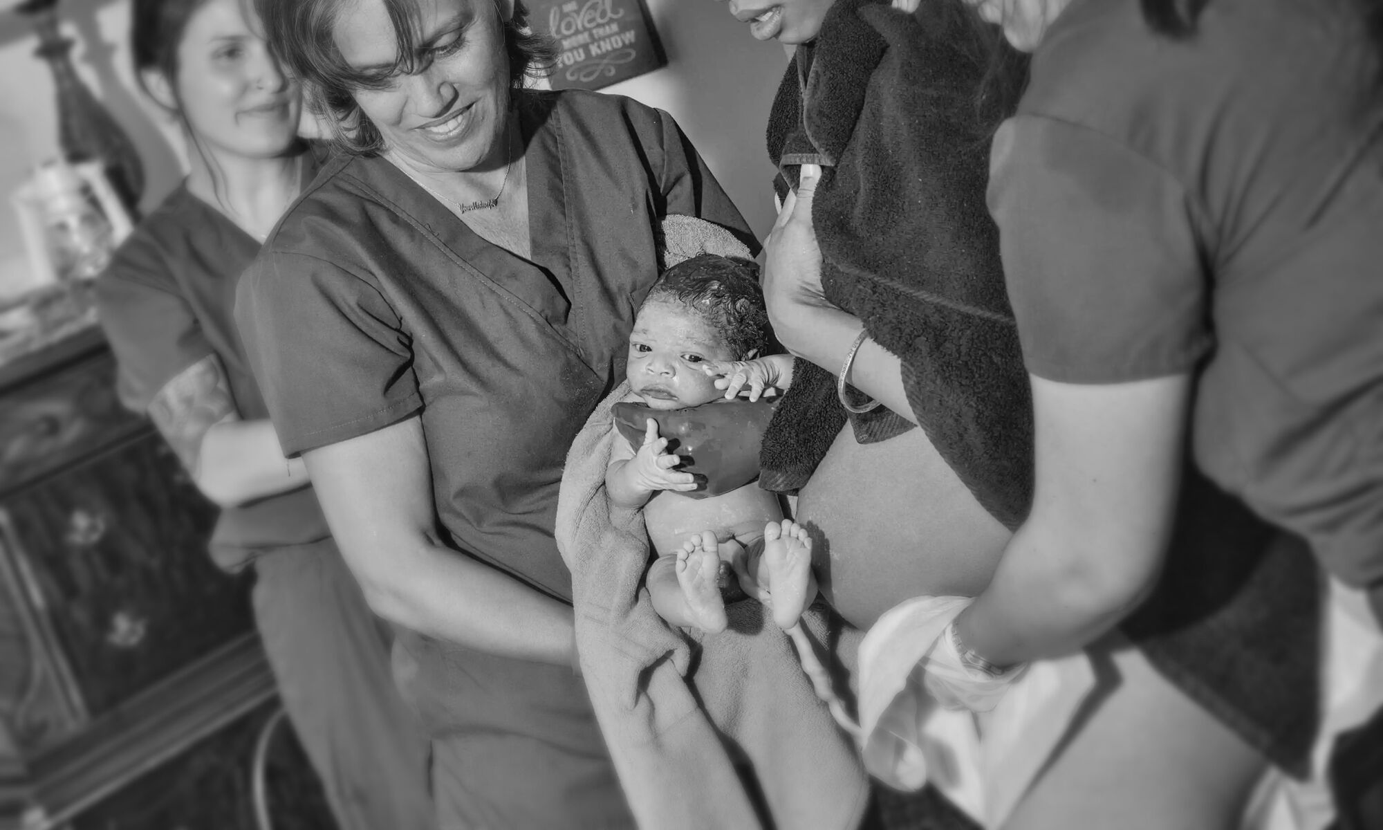A young family of four, each parent holding one of their babies
