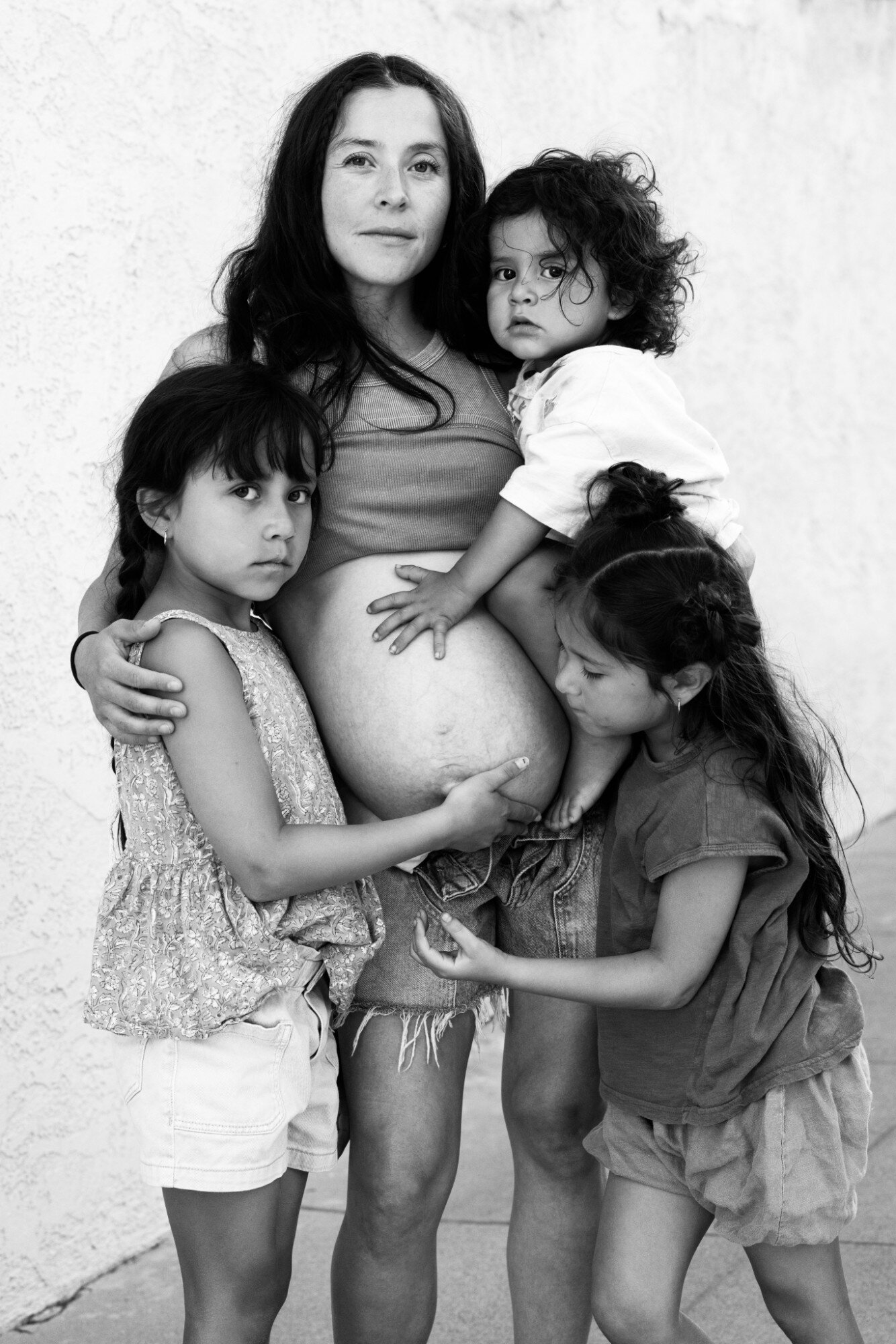 An expecting mother surrounded by her three children