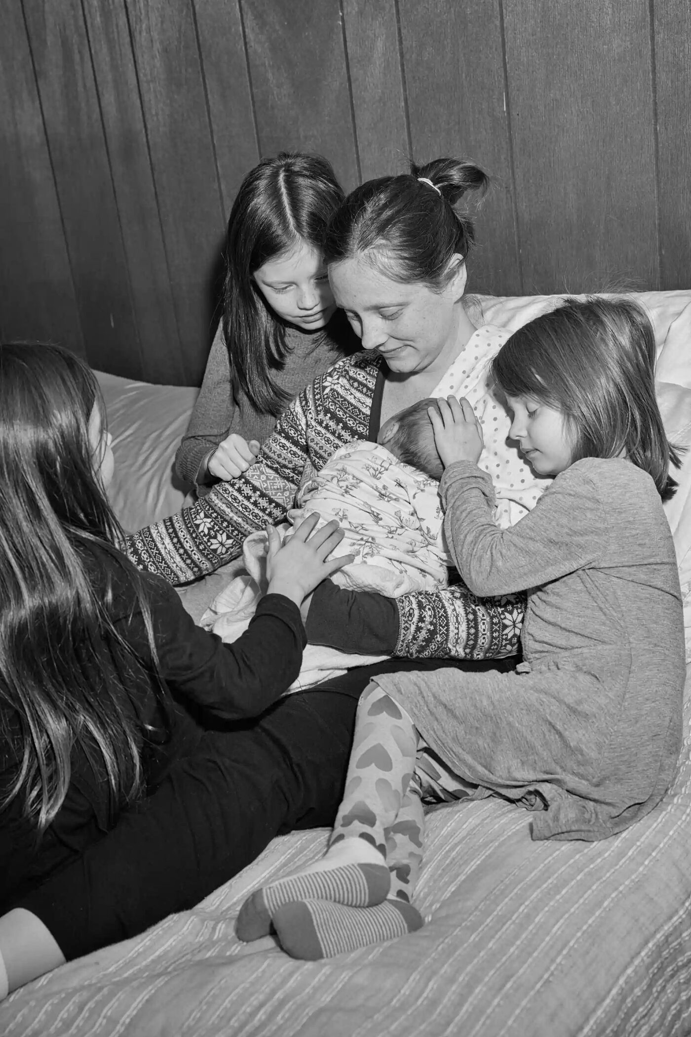 A mother resting with her children after birth