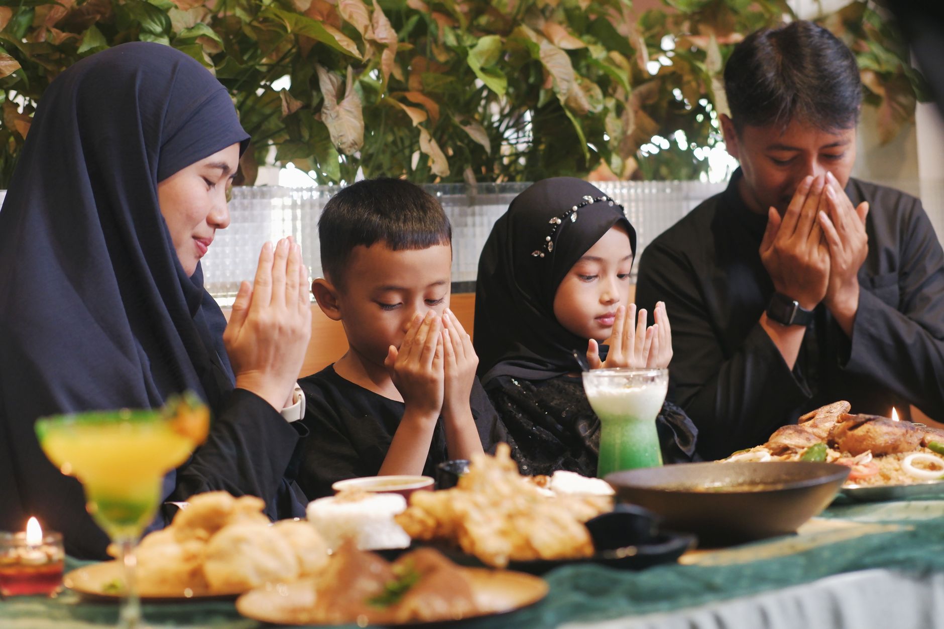A multi-generational family breaking fast together at sunset.