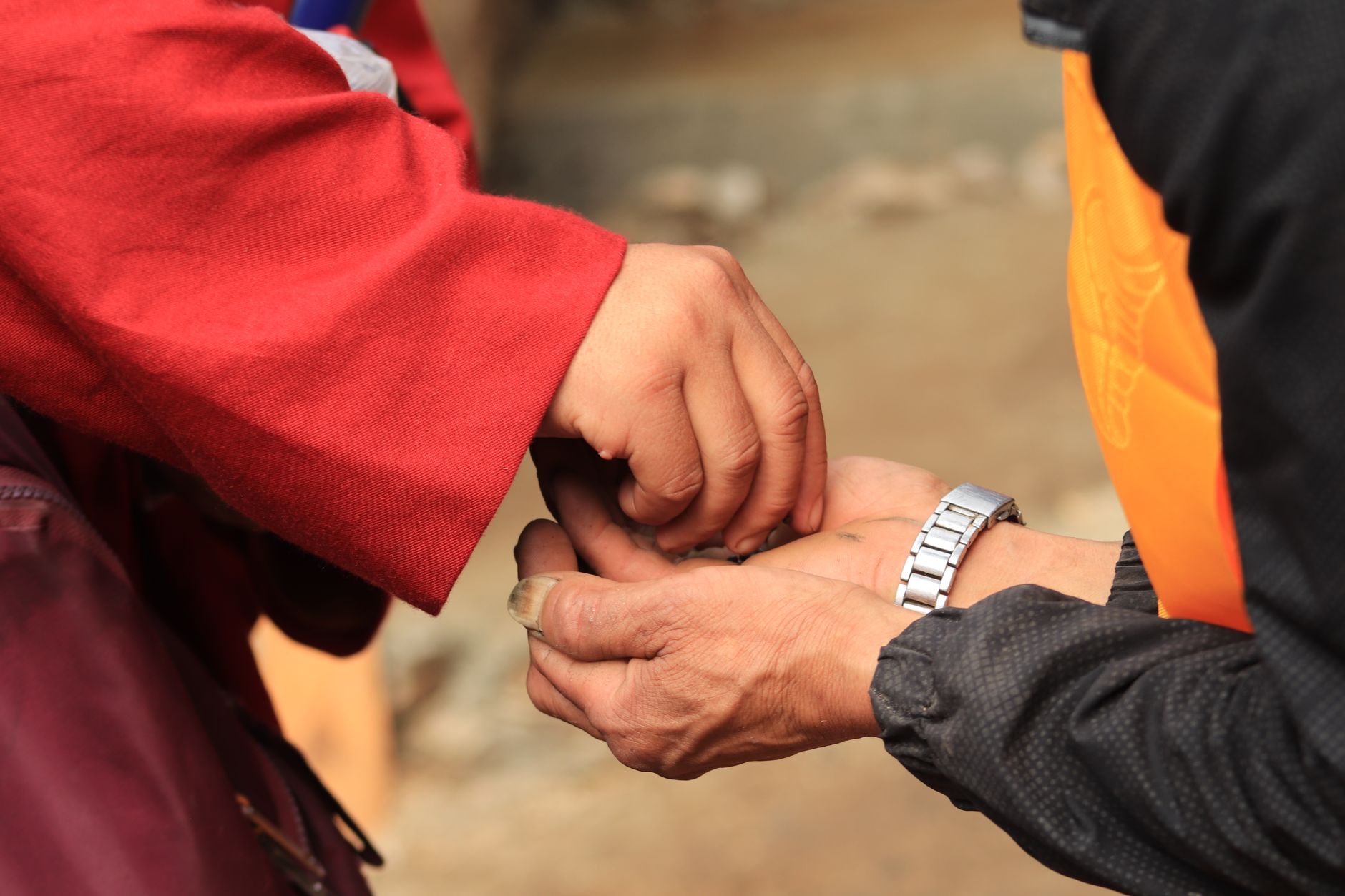 Hands joined in giving, with community members passing support forward.