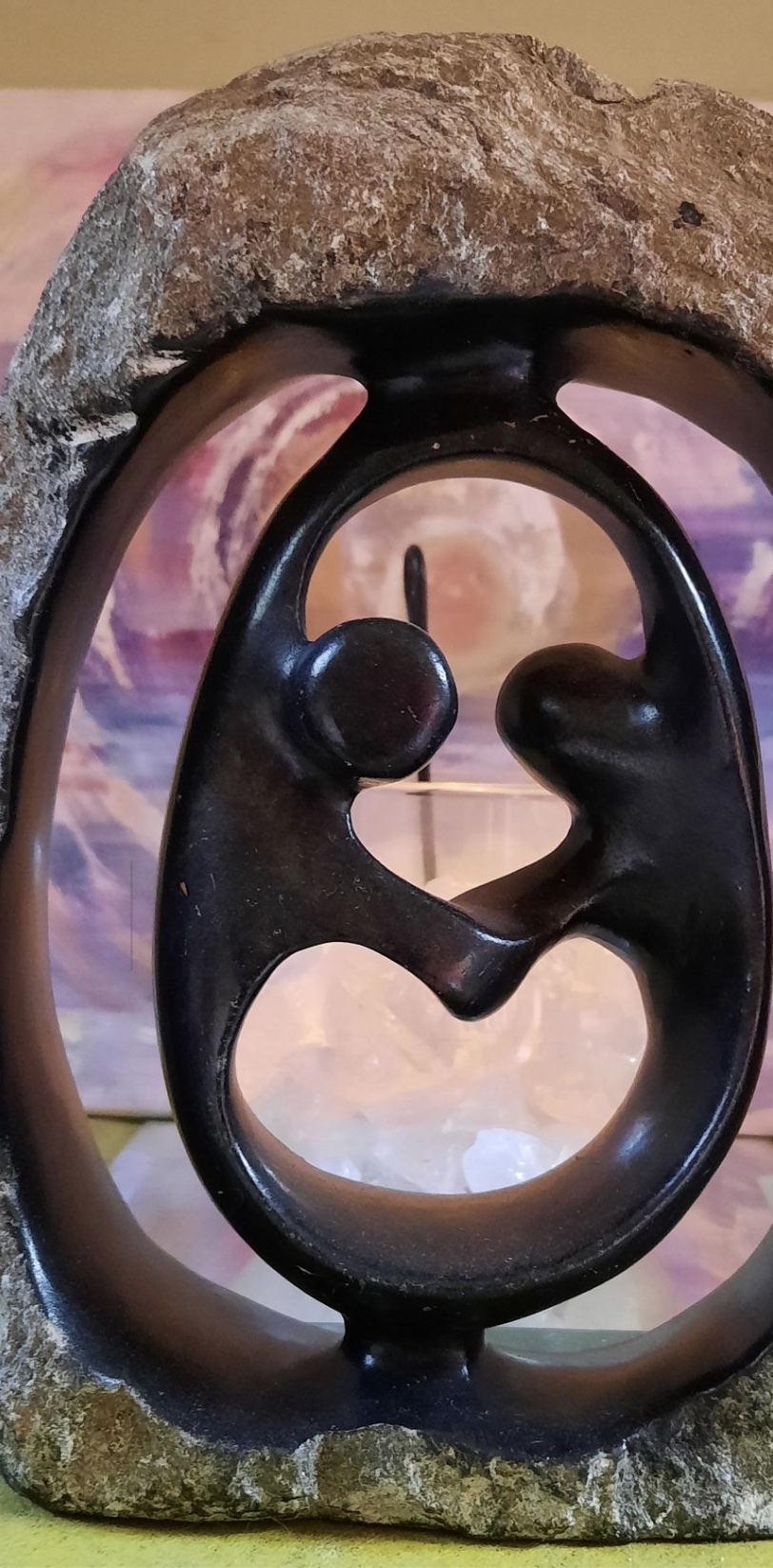 Stenen beeld van twee omhelzende figuren