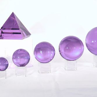 Paarse bollen en een piramide op een rij