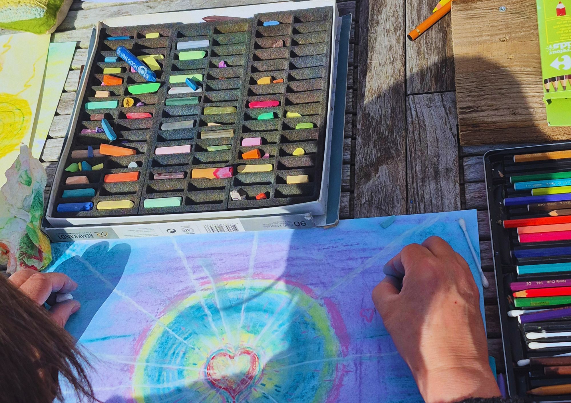 Pastelkrijt en tekeningen op tafel tijdens een creatieve workshop