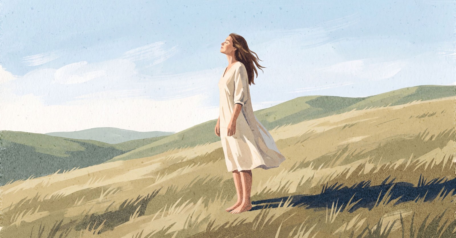 A woman stands barefoot on a grassy hillside with her face lifted to the sun and her eyes closed, her dress moving in the wind, with green hills and a pale blue sky behind her.