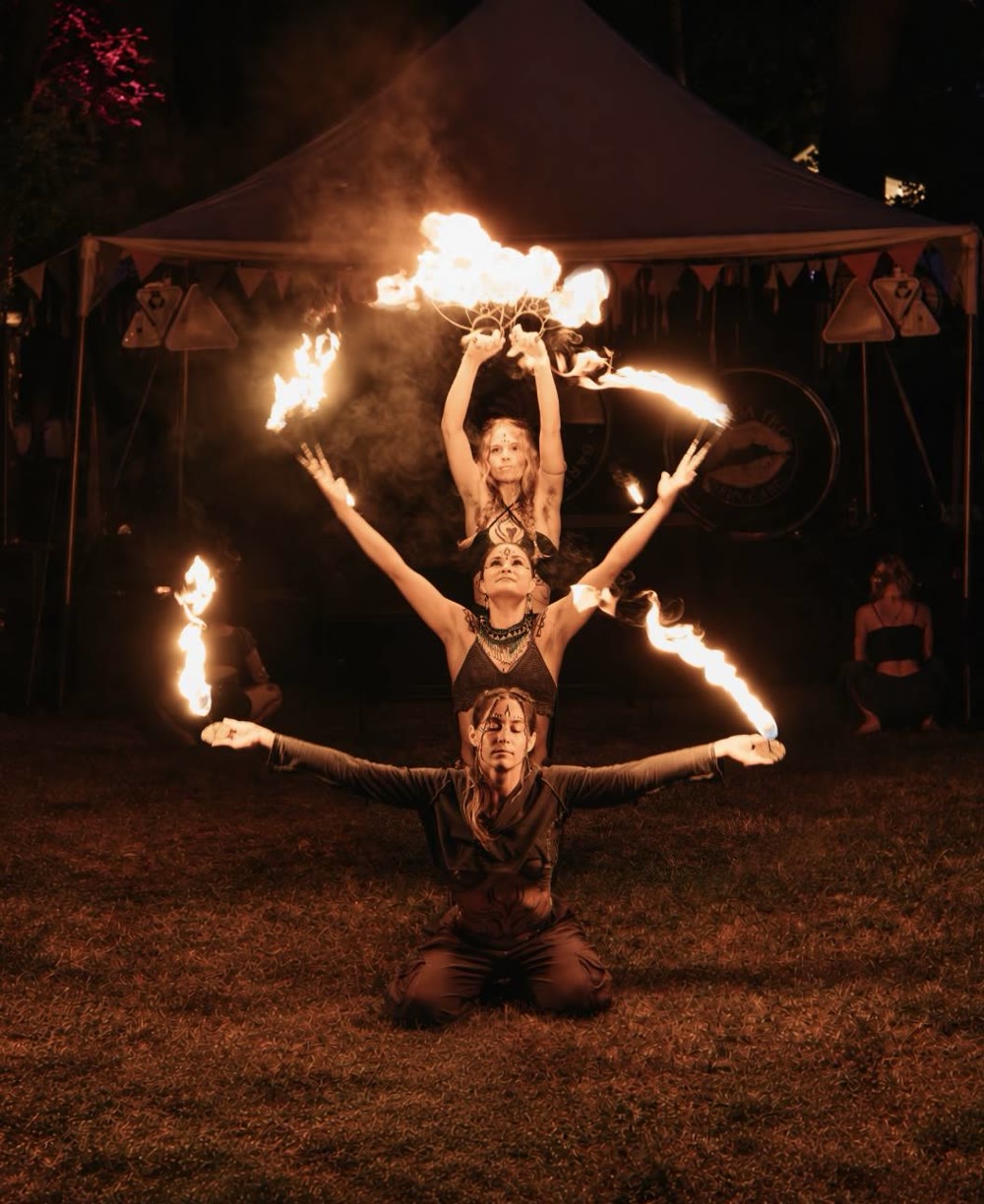 Three Symbiotica performers posing with fire