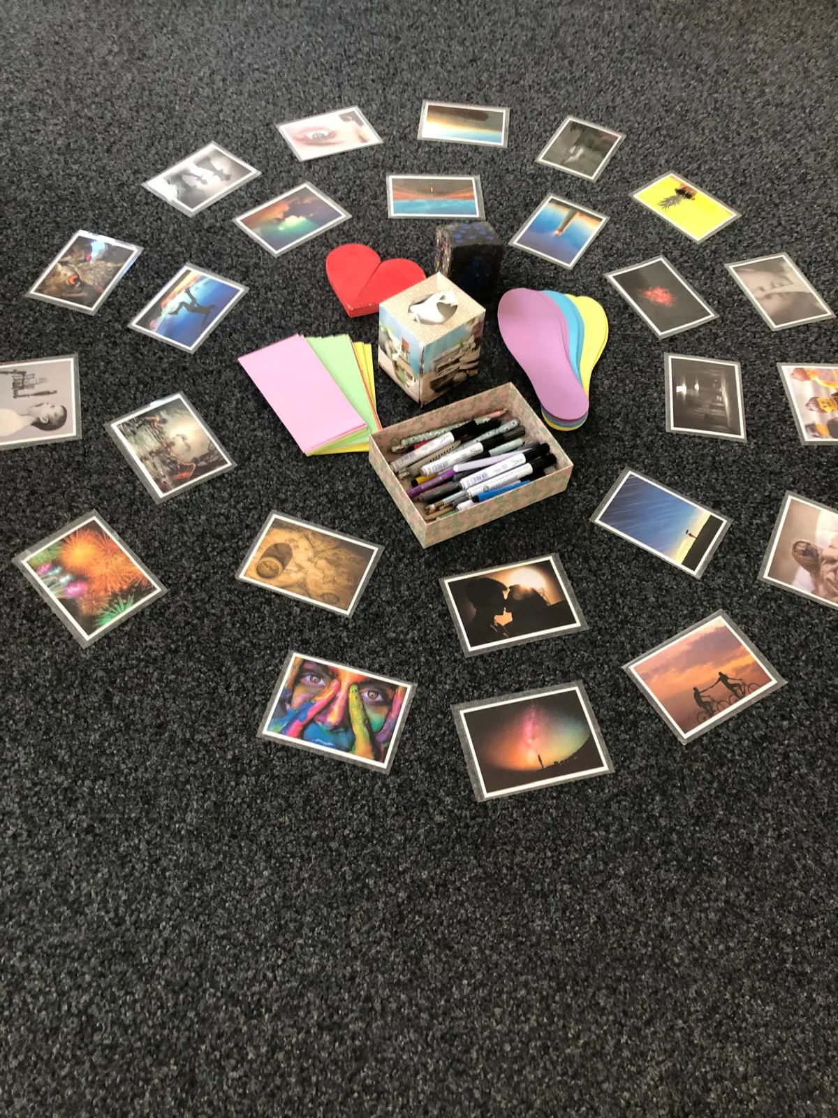 Fotokarten, Stifte und Holzherz im Kreis als Impulse für einen Kreativworkshop