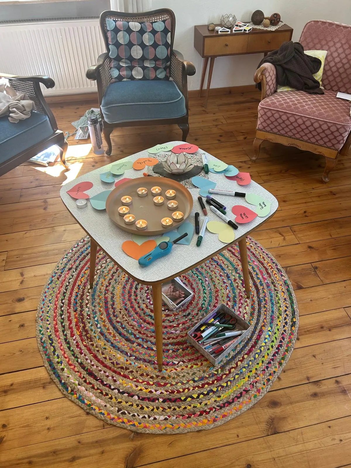 Vorbereiteter Tisch mit Kerzen, bunten Herzen und Stiften für einen Kreativworkshop