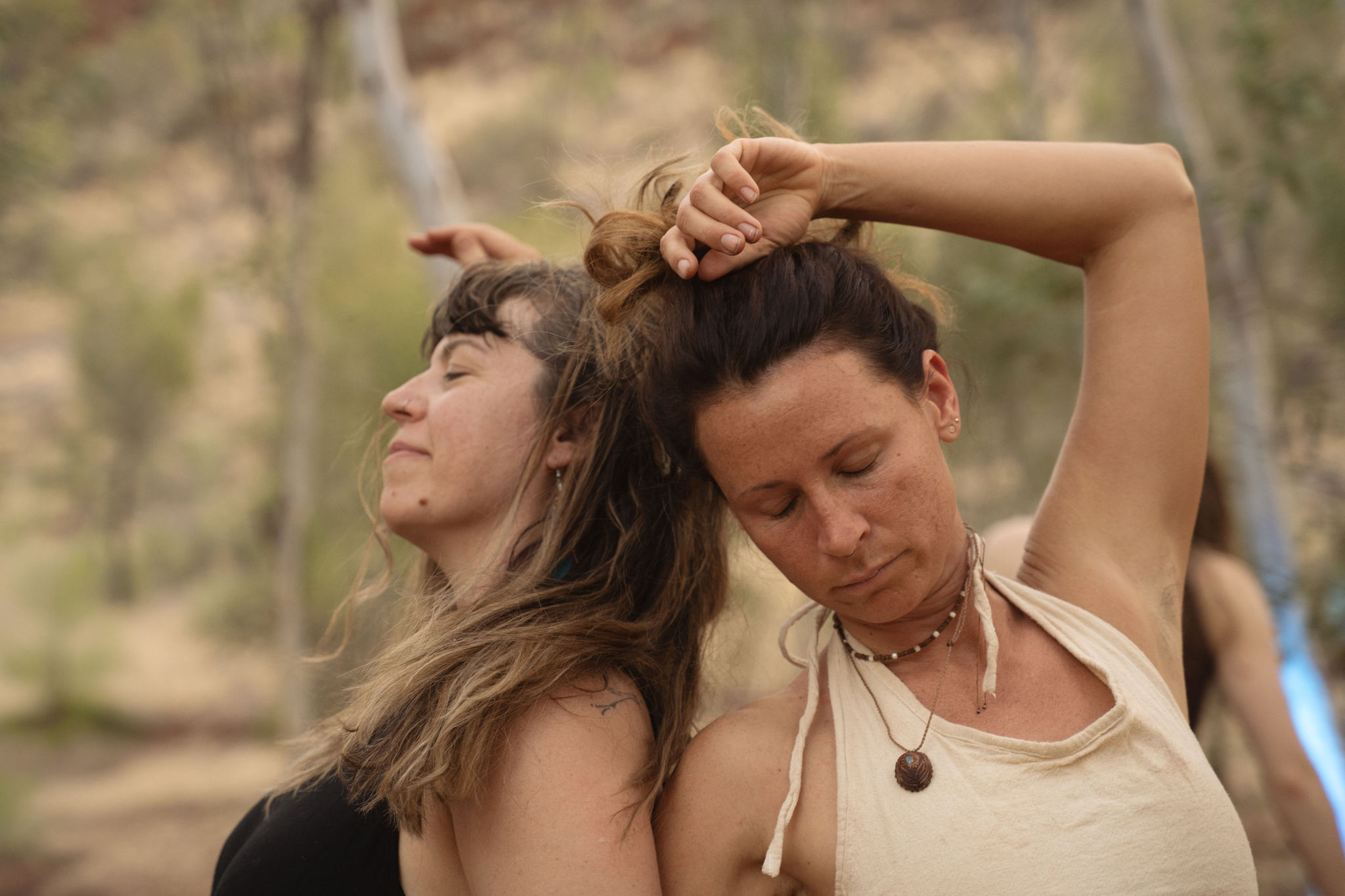 Two women dancing together in the Australian bush