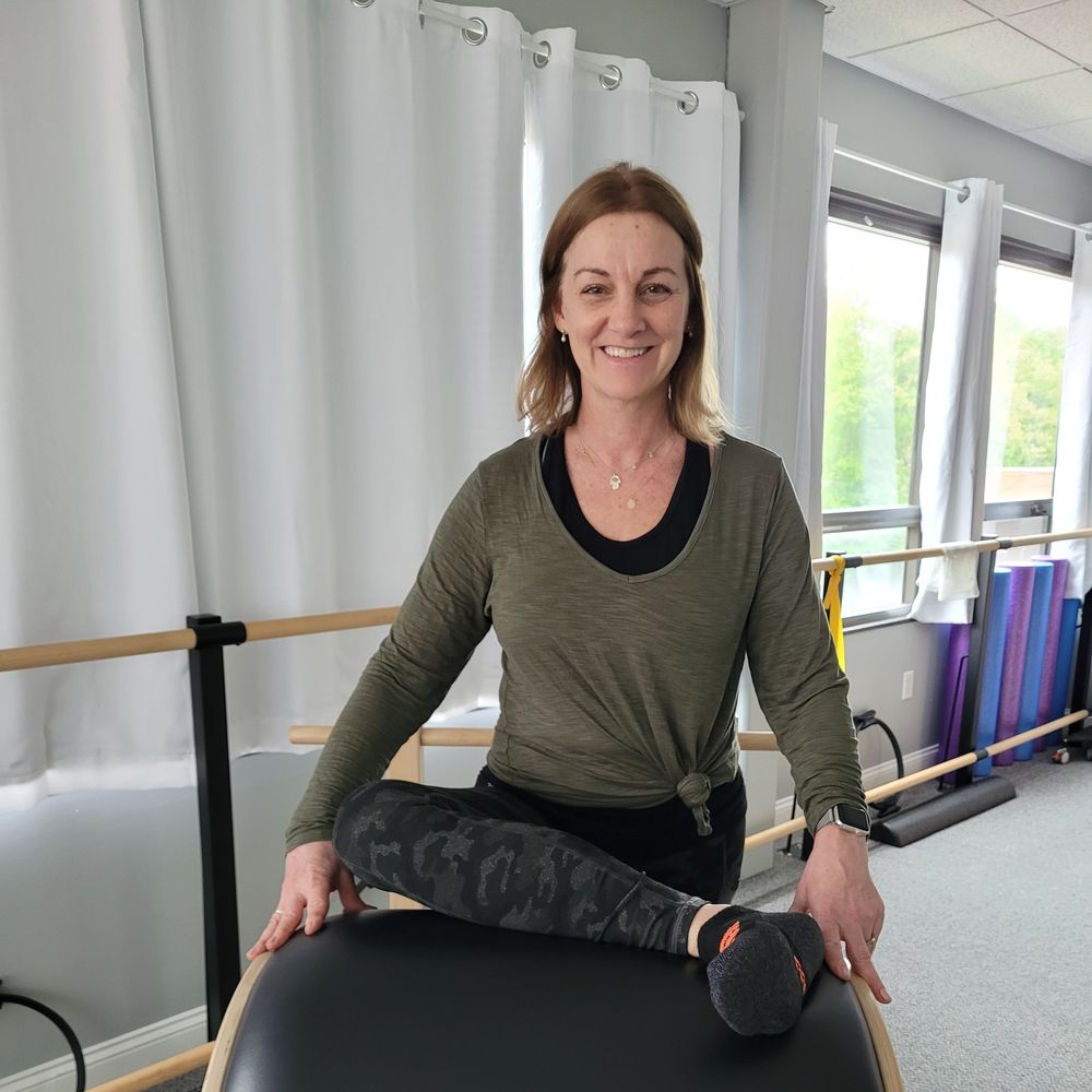 Regina Hodel sitting on a Pilates barrel