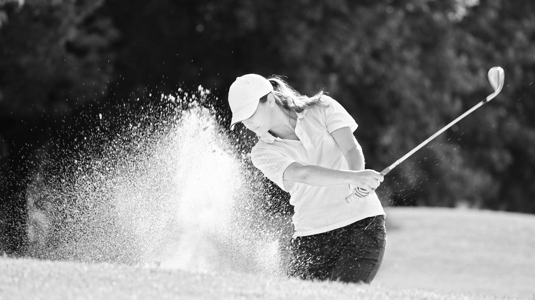 A golfer hitting out of a bunker