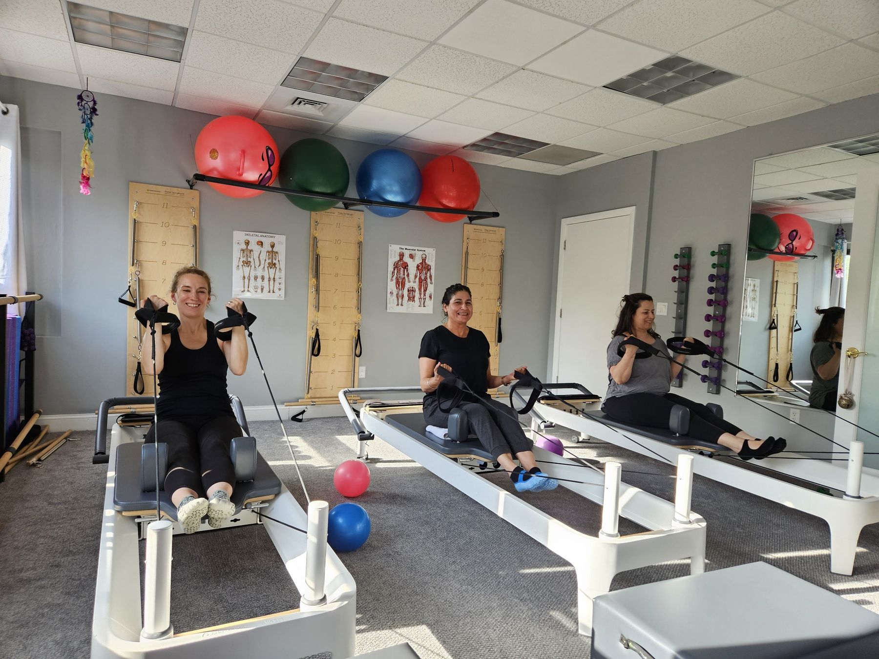 Clients working out together on Pilates reformers