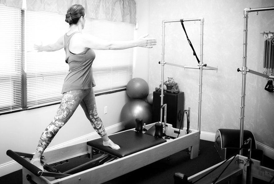 A woman exercising on Pilates equipment