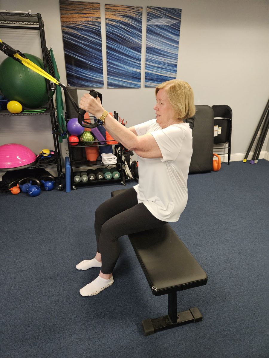 A client training with resistance bands on a bench