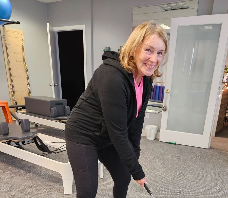 A client practicing a golf swing in the studio