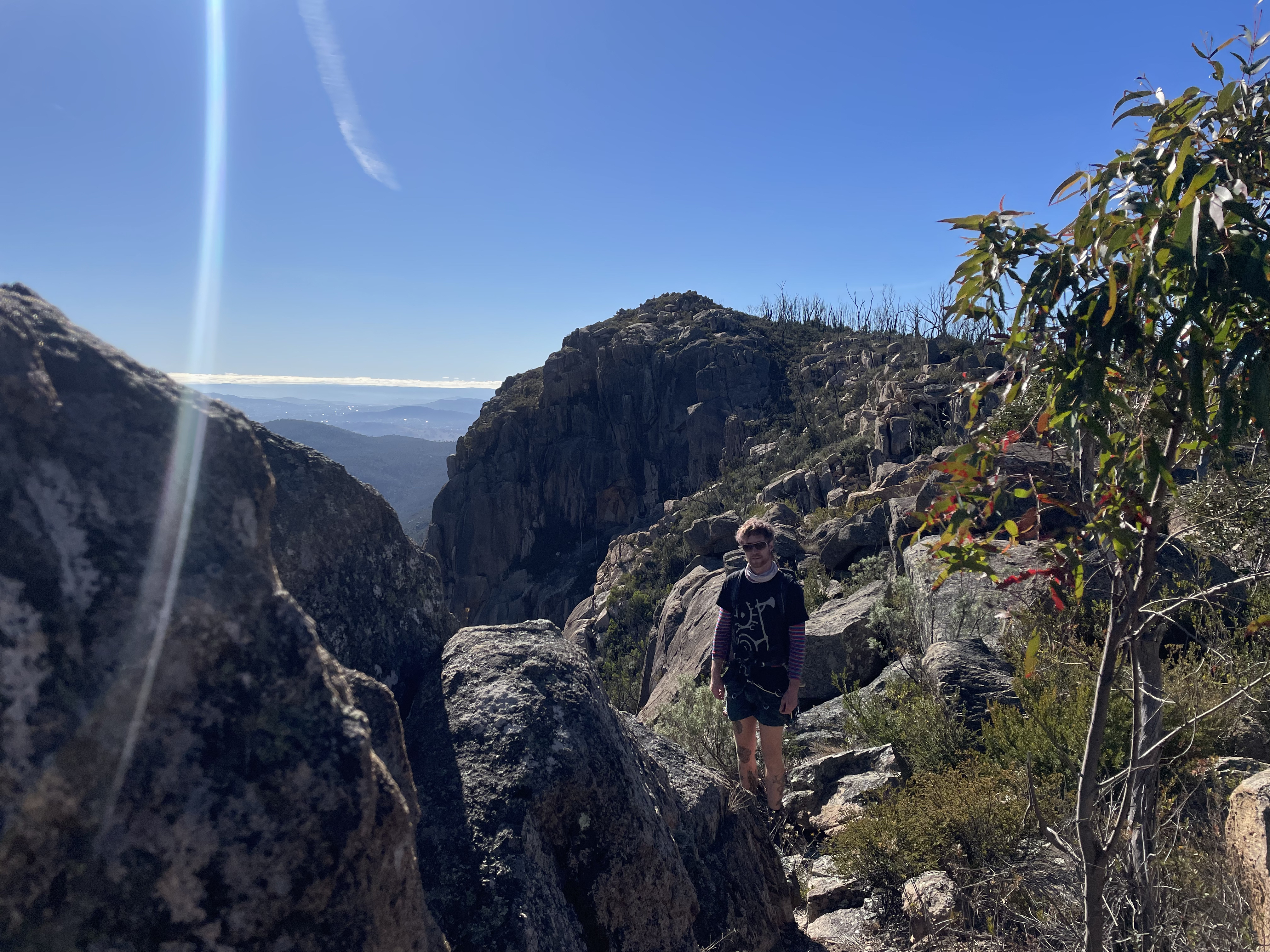 Jayden standing in the sun at the top of Booroomba Rocks