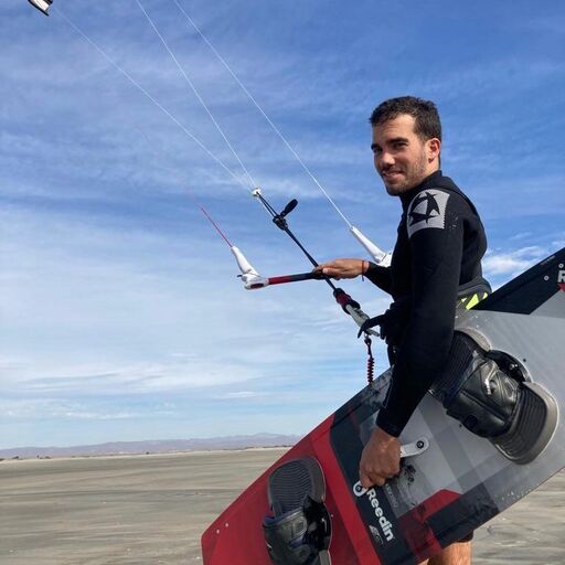 Alex Salvador walking to the water with a Reedin board and kite