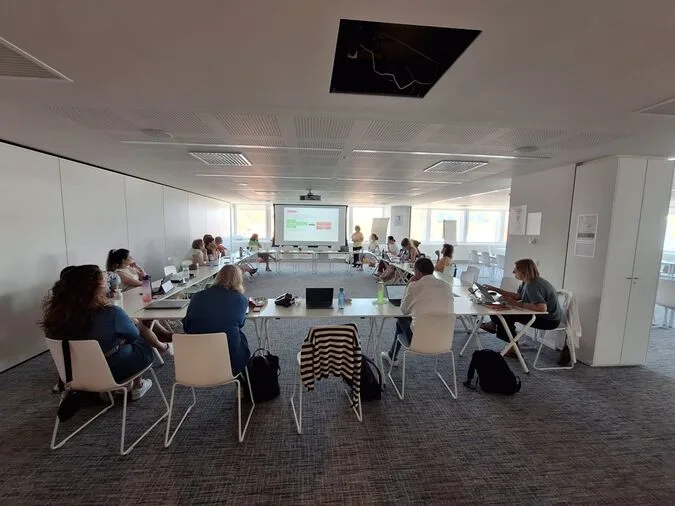 Hanne geeft een vorming aan een groep deelnemers