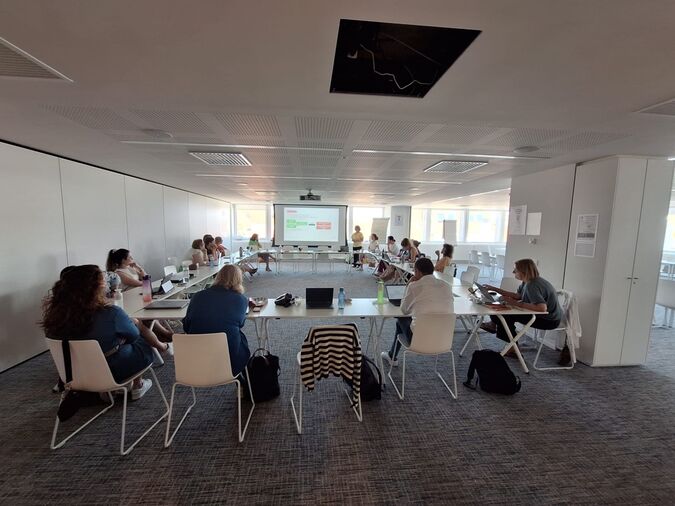 Hanne geeft een vorming aan een groep deelnemers