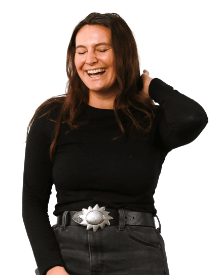 Rachel is wearing a black jumper. Her eyes are closed as she laughs with a wide smile. 