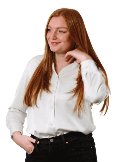 Rosie is wearing a white shirt and black jeans as she looks off-camera, smiling as she is photographed mid hair flick.