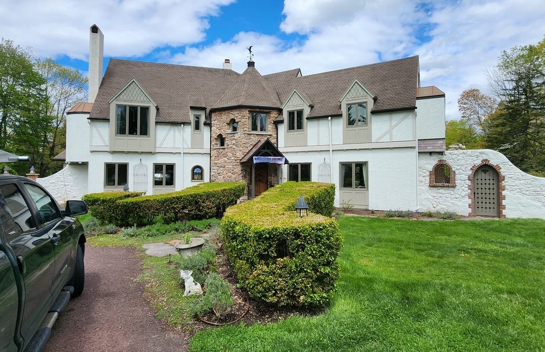 Renovated facade of a large two-story home after extensive rot repair on exterior trim and window frames