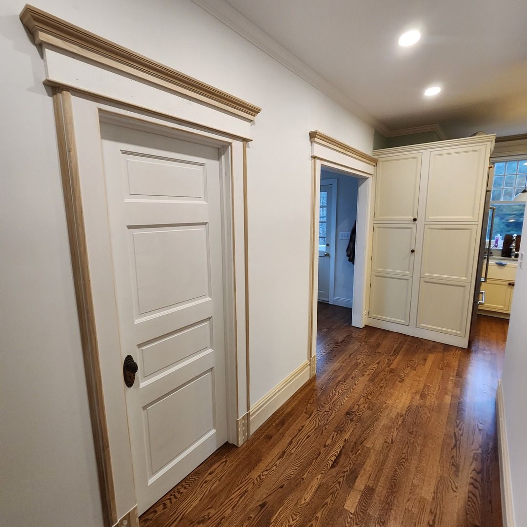 Hallway and kitchen of a 1910 home in Princeton, NJ, fully restored with custom trim after flood damage
