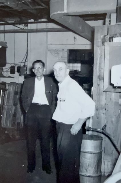 Two men standing on a furniture plant floor, 1956