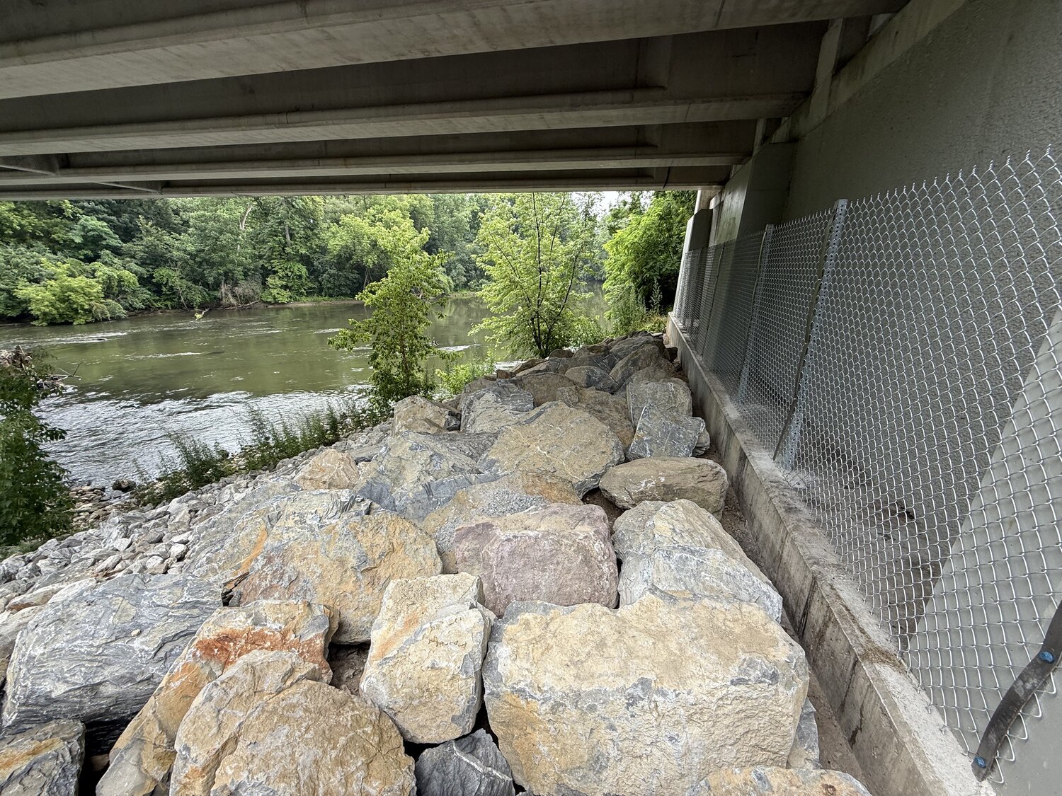 Large boulders and new chain link fencing installed under a bridge in Middlebury where people once sheltered
