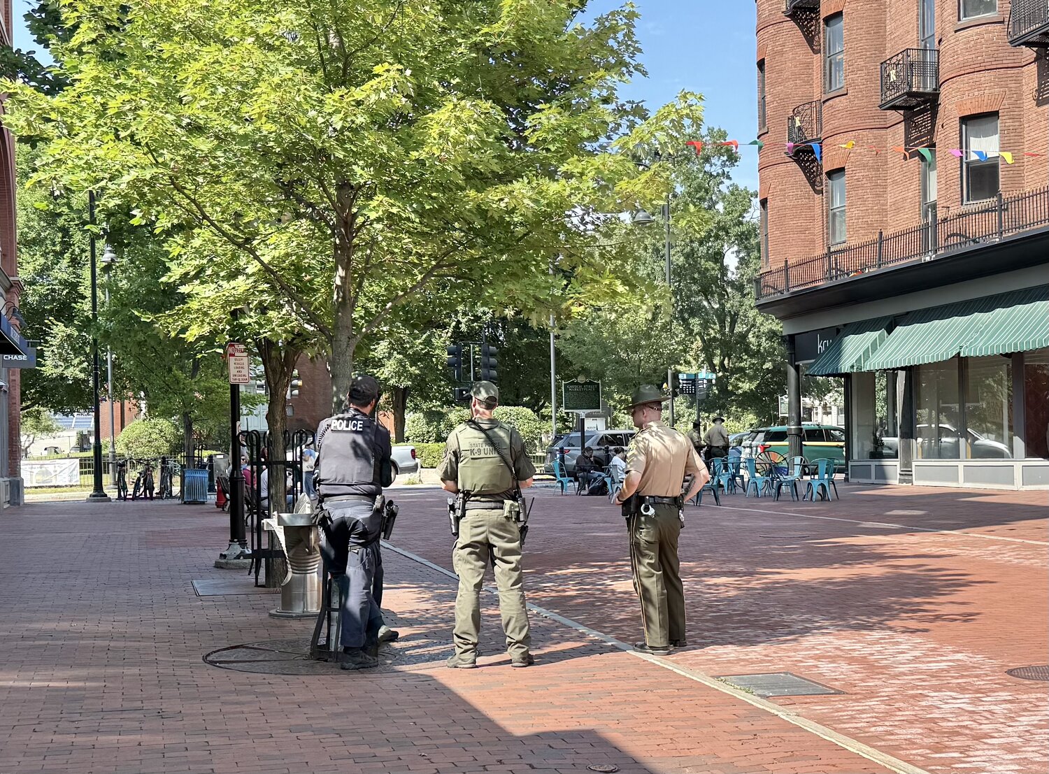 Burlington police officer, State Police K-9 unit trooper, and a State Police trooper on the Church Street Marketplace
